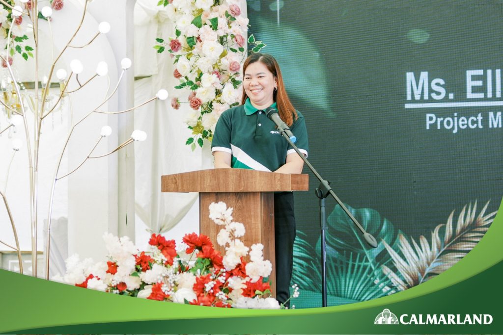 Ellen Grimaldo, Project Management Director of Calmar Land, speaking at a podium during a groundbreaking event.