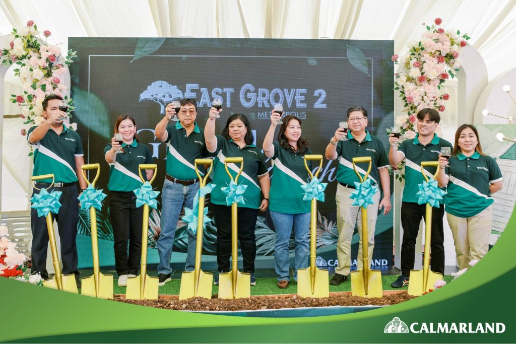 Calmar Land team celebrating the groundbreaking ceremony of East Grove 2 with gold shovels and wine glasses, set against a decorated backdrop